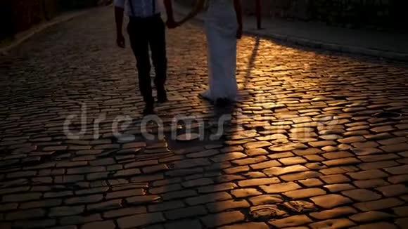 幸福的新郎和新娘在老城街散步微笑着亲吻视频的预览图