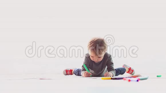 小男孩在白纸上画彩色铅笔视频的预览图