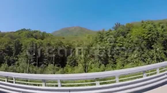 汽车在夏季的公路上行驶场景乘车前往阳光路山区视频的预览图