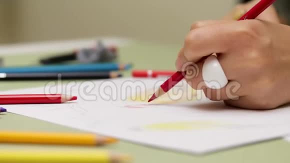女孩用红铅笔左撇子画在纸上用慢镜头细看视频的预览图