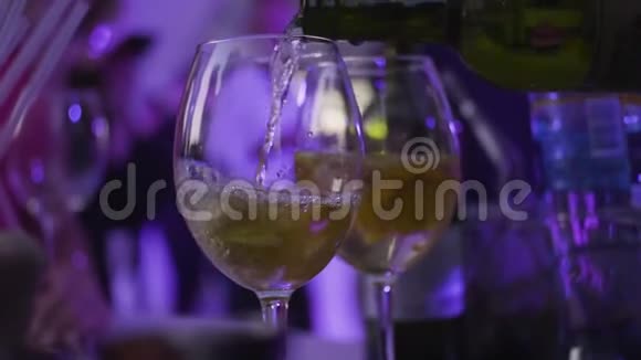 特写酒杯倒白葡萄酒在夜总会框架将含酒精的饮料倒入玻璃杯中用于夜间聚会视频的预览图