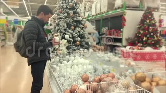 在商店买圣诞树装饰品的人视频的预览图
