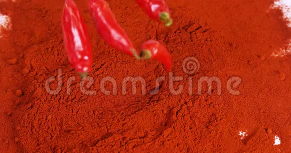 新鲜红辣椒辣椒落在红辣椒粉上慢动作视频的预览图