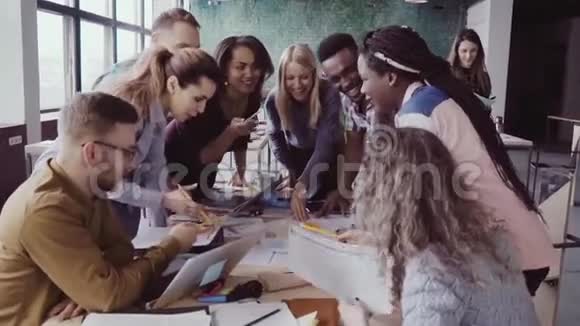 近距离观看年轻的商业团队与女组长一起在餐桌附近工作积极集思广益视频的预览图