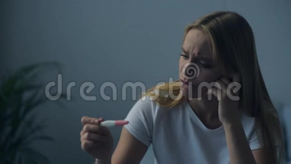 沮丧的女孩看着怀孕测试视频的预览图