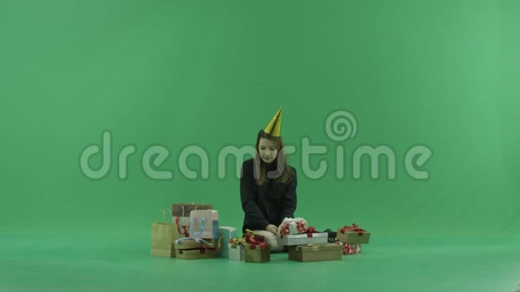 年轻女子看着里面的购物袋绿色彩色钥匙背景视频的预览图