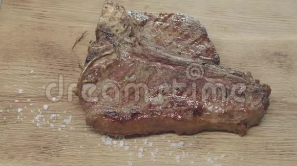 调味料被倒入成品多汁的牛排上火烤肉在木板上视频的预览图
