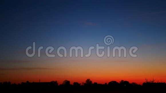 日落时分一个遛着的年轻女孩和一只狗对着天空的剪影视频的预览图