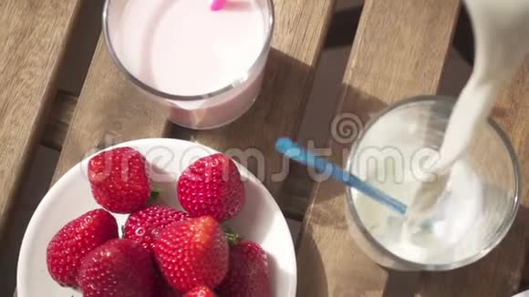 慢动作草莓和巧克力牛奶放在杯子旁边然后倒入牛奶视频的预览图