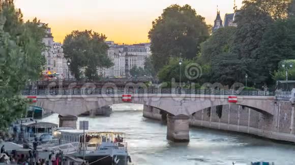 临近巴黎圣母院大教堂的河流和桥梁日落后白天到夜间时间视频的预览图