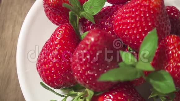 慢动作草莓放在盘子和一杯天然果汁上视频的预览图
