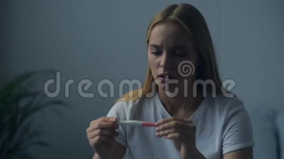 接近悲伤的女人看怀孕测试结果视频的预览图