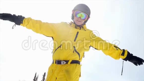 微笑的人戴着滑雪眼镜在多云的蓝天上的肖像在缓慢的运动中随着太阳升起3840x2160视频的预览图