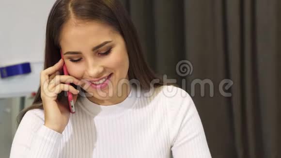 漂亮的年轻商务女性在电话里愉快地笑着视频的预览图