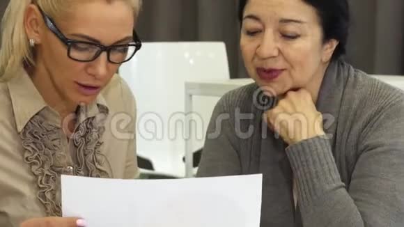 两个商务女性在办公室讨论文件视频的预览图