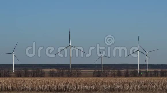 春季景观风力发电厂有干草的田野裸露的树木地平线视频的预览图