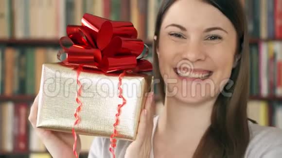 带礼物的年轻女人女性手持金色礼盒红色丝带庆祝生日视频的预览图