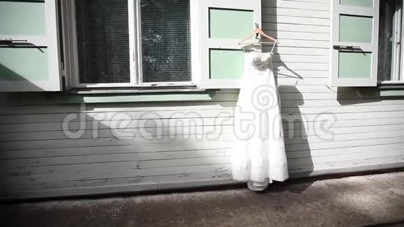 婚礼前一天白色婚纱挂在白色木屋背景上贴在白色墙壁上视频的预览图