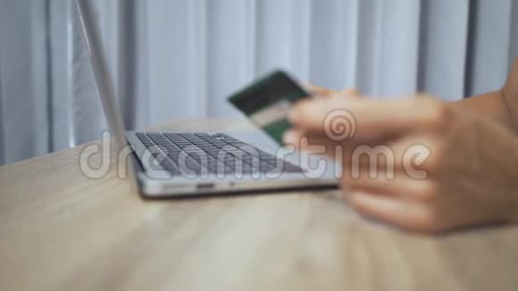 网上购物概念女人手拿信用卡用手提电脑视频的预览图