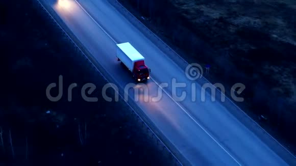日落时乘坐巨大立交桥的卡车的鸟瞰图视频的预览图