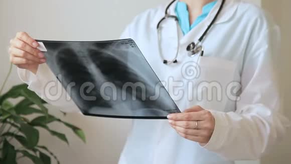 年轻医生在室内诊所看胸部X线片视频的预览图