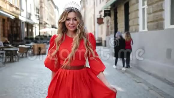 女孩金发穿着一件红色的裙子头上戴着一顶皇冠摆姿势拍照视频的预览图