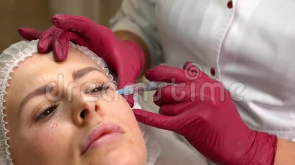 美容师在美容院注射透明质酸后将年轻女性的面部特写视频的预览图