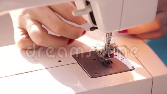 女人用现代缝纫机缝纫在机器上缝纫时支撑羊毛布的手蓝色织物女人视频的预览图