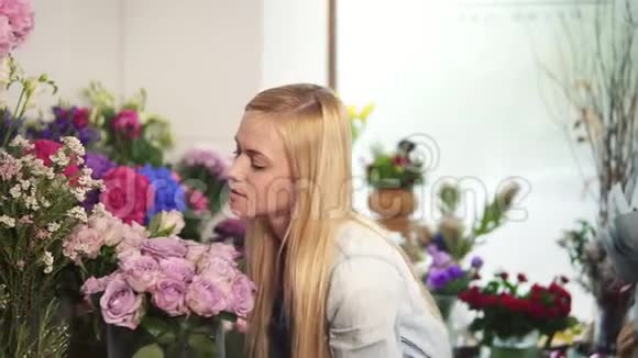 围裙的女性在花店工作并在货架上摆放花盆她感觉到一股完美的香味视频的预览图