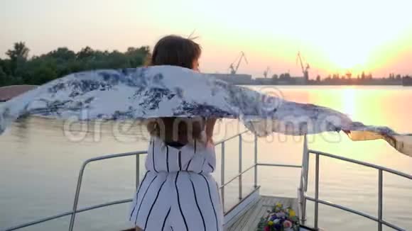 夏日的海上周末夕阳西下微笑的女孩在游艇上挥舞着布视频的预览图