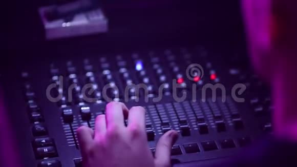 在一个著名乐队的音乐会上一名男子的手控制着音响设备音响面板视频的预览图