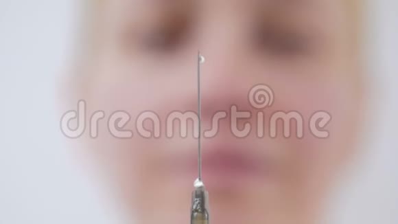 一位女医生面部模糊用针头集中注射器液体泄漏视频的预览图