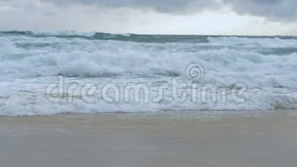 海水缓慢运动巨浪在雨云下拍打海滩视频的预览图