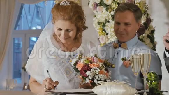 快乐的成年新娘签署结婚证书视频的预览图