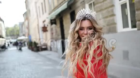 女孩金发穿着一件红色的裙子头上戴着一顶皇冠摆姿势拍照视频的预览图