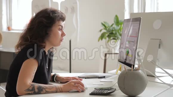 女专家在电脑工作与同事交谈坐在公司里视频的预览图