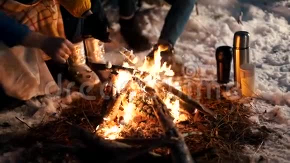 冬天森林里的篝火晚上油炸棉花糖热电偶站在雪地里视频的预览图