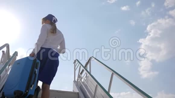 穿制服的空姐站在飞机楼梯上拿着手提箱和护照和机票视频的预览图