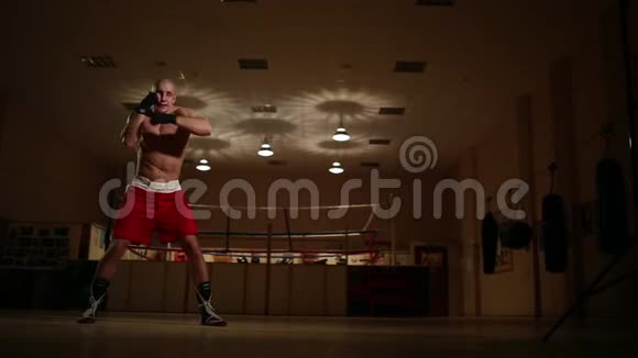 在健身房戒指的背景上拳击手在空中进行动态运动练习视频的预览图