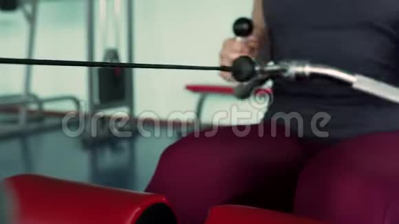 运动女性在模拟器机器上训练背部肌肉视频的预览图