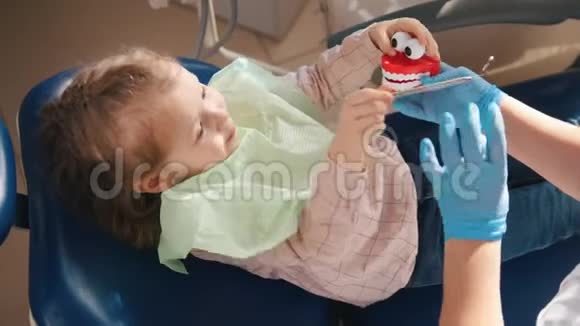 小女孩坐在牙科椅上玩牙科工具和玩具视频的预览图