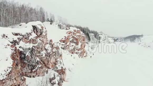 空中射击多雪的岩石山日落或日出晴空万里阳光明媚冬林中落石山视频的预览图