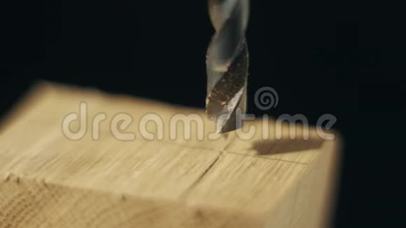 一个钻坑正穿入一个木块中形成一个洞变焦近景慢镜头视频的预览图