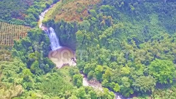Drone从丛林中的粘土河上飞起瀑布视频的预览图