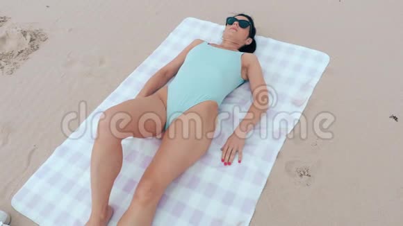穿着泳衣睡在沙滩上的女人视频的预览图