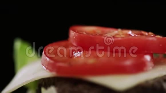 切碎的新鲜西红柿和腌制的黄瓜落在汉堡里的奶酪上视频的预览图