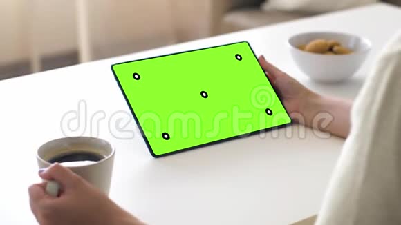 平板电脑和咖啡上有绿色屏幕的手视频的预览图