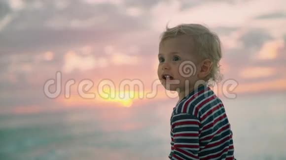 一个小可爱的孩子在夏天的海滩上微笑50fps慢动作暑假佛罗里达男孩肖像视频的预览图