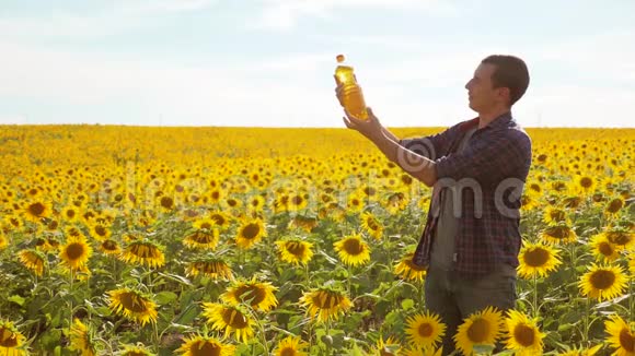 日落时分农夫手里拿着一瓶葵花油葵花籽油能改善皮肤健康促进细胞生长视频的预览图