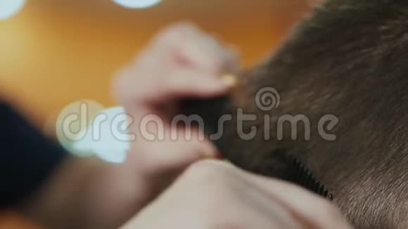 在美发沙龙剪小男孩头发的理发师的双手合拢有选择的焦点头发视频的预览图